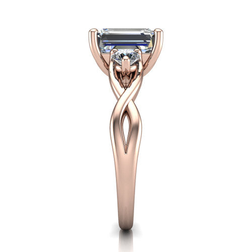 Lydia emerald three stone engagement ring in 18K Rose Gold, side profile showing the round side diamonds, floral gallery, and woven infinity shank