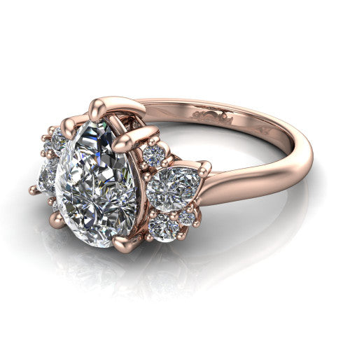 Evie pear three stone engagement ring in 14K Rose Gold, three-quarter perspective showing the cathedral rise and accent clusters fanning out on both sides of the center