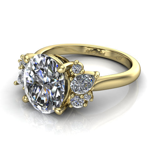 Evie oval three stone engagement ring in 18K Yellow Gold, three-quarter perspective showing the cathedral rise and accent clusters fanning out on both sides of the center