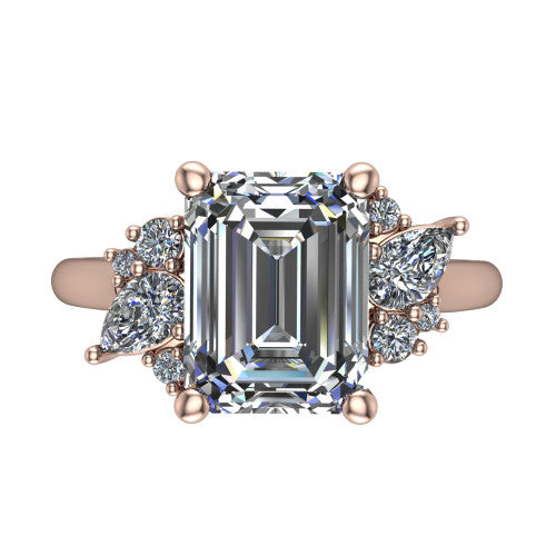 Genevieve emerald three stone engagement ring in 18K Rose Gold, three-quarter perspective showing the step-cut emerald center diamond flanked by clusters of small round accent diamonds on tapered cathedral shoulders