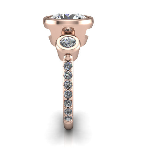Chloe round three stone engagement ring in 14K Rose Gold, side profile showing the round bezel side stone and the pavé diamonds running down the shank