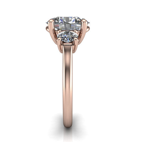 Emma oval three stone engagement ring in 18K Rose Gold, side profile showing the round side stone and the smooth tapered polished band