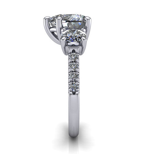 Celeste heart three stone engagement ring in 18K White Gold, side profile showing the round side stone and the pavé diamonds running down the shank