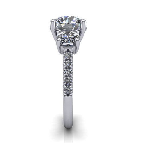 Celeste round three stone engagement ring in 18K White Gold, side profile showing the round side stone and the pavé diamonds running down the shank