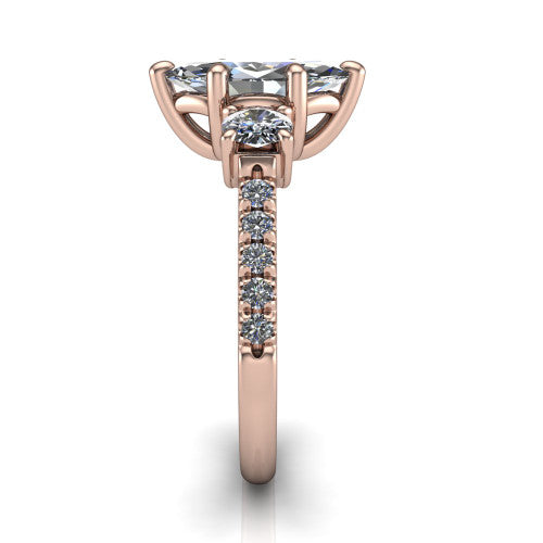 Celeste marquise three stone engagement ring in 18K Rose Gold, side profile showing the round side stone and the pavé diamonds running down the shank