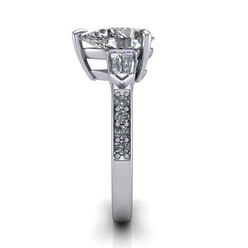 Audrey pear three stone engagement ring in 18K White Gold, side profile showing the tapered baguette side stone and the round diamonds running down the shank
