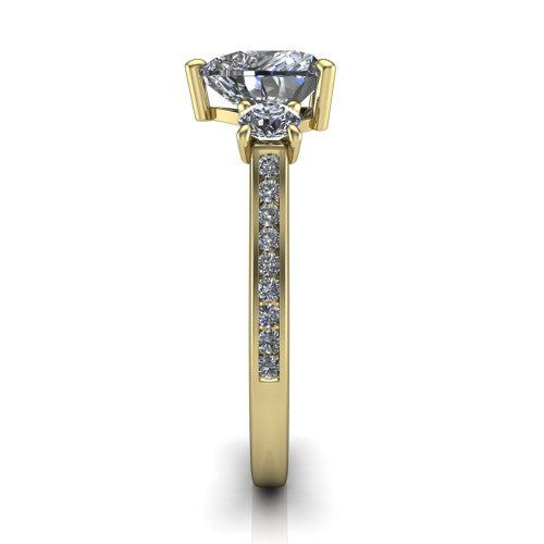 Saoirse heart three stone engagement ring in 18K Yellow Gold, side profile showing the round side stone and the pavé diamonds running down the shank