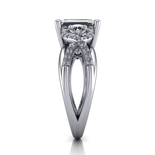 Amara emerald three stone engagement ring in Platinum, side profile showing the pavé rails crossing in an infinity twist beneath the head