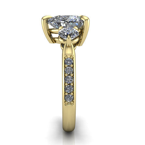 Blake heart three stone engagement ring in 18K Yellow Gold, side profile showing the round side stone and the pavé diamonds running down the shank