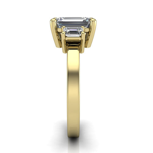 Madelyn emerald three stone engagement ring in 18K Yellow Gold with emerald-cut side stones, side profile showing the plain band and step-cut side stones