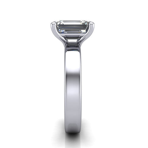 Louise emerald classic solitaire engagement ring in Platinum, side profile showing the substantial flat polished band and the open basket beneath the emerald center