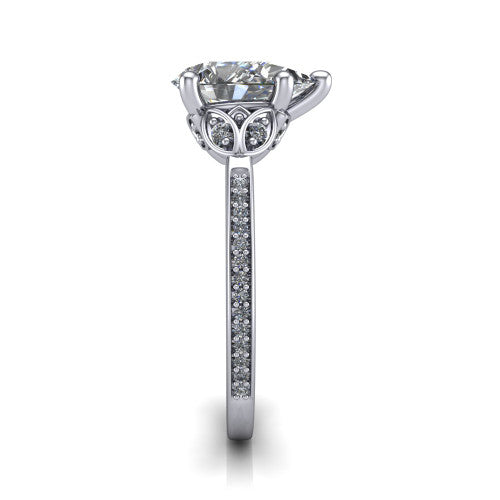 Lena pear solitaire engagement ring in Platinum, side profile showing the petal basket and pave band