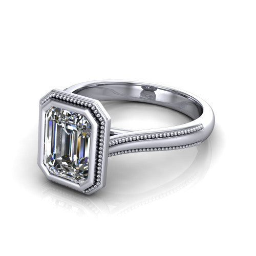 Adelina emerald solitaire engagement ring in 14K White Gold, three-quarter perspective showing the step-cut emerald center diamond, full bezel setting with milgrain detail, and tapered split-shoulder shank