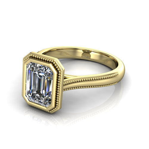 Adelina emerald solitaire engagement ring in 18K Yellow Gold, three-quarter perspective showing the step-cut emerald center diamond, full bezel setting with milgrain detail, and tapered split-shoulder shank