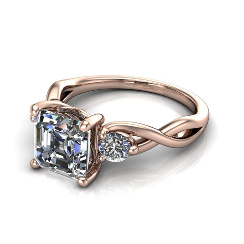 Lydia square emerald three stone engagement ring in 14K Rose Gold, three-quarter perspective showing the step-cut square emerald center diamond flanked by two round side diamonds on a woven infinity shank