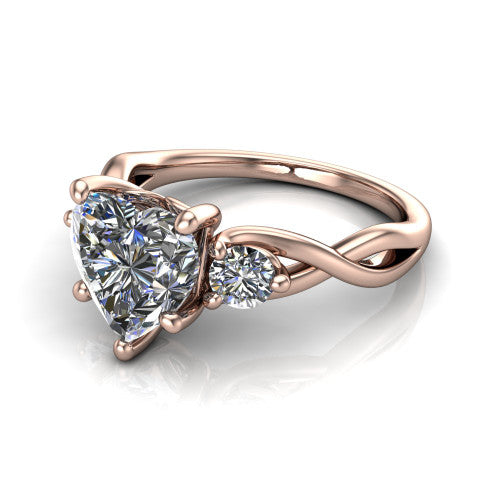Lydia heart three stone engagement ring in 18K Rose Gold, three-quarter perspective showing the brilliant heart-shaped center diamond flanked by two round side diamonds on a woven infinity shank