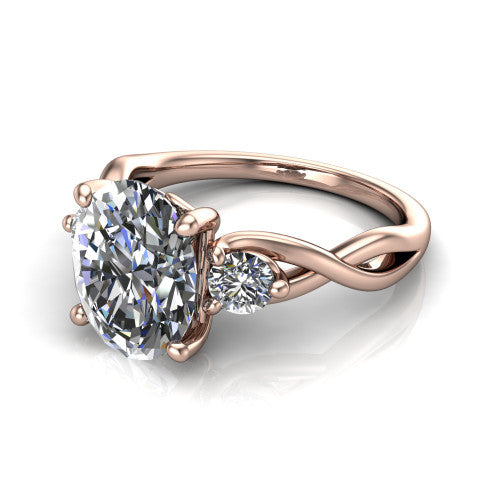 Lydia oval three stone engagement ring in 14K Rose Gold, three-quarter perspective showing the brilliant oval center diamond flanked by two round side diamonds on a woven infinity shank