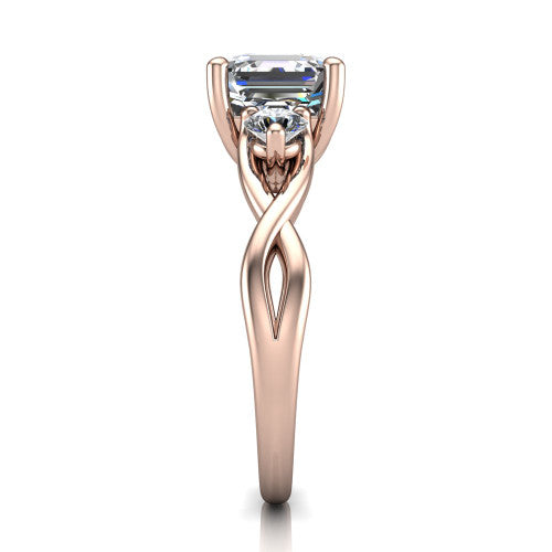 Lydia square emerald three stone engagement ring in 14K Rose Gold, side profile showing the round side diamonds, floral gallery, and woven infinity shank