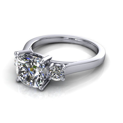 Olivia cushion three stone engagement ring in 18K White Gold, three-quarter perspective showing the brilliant cushion-cut center diamond flanked by two round side diamonds on a squared flat-top shank