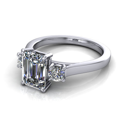 Olivia emerald three stone engagement ring in 14K White Gold, three-quarter perspective showing the step-cut emerald center diamond flanked by two round side diamonds on a squared flat-top shank