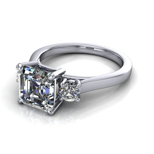 Olivia square emerald three stone engagement ring in 14K White Gold, three-quarter perspective showing the step-cut square emerald center diamond flanked by two round side diamonds on a squared flat-top shank