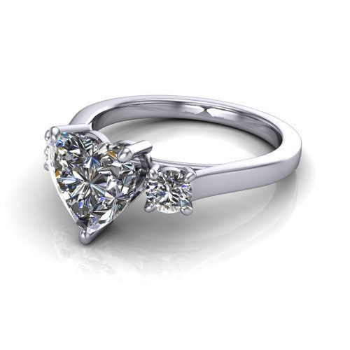 Olivia heart three stone engagement ring in Platinum, three-quarter perspective showing the brilliant heart-shaped center diamond flanked by two round side diamonds on a squared flat-top shank