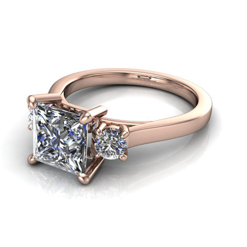 Olivia princess three stone engagement ring in 14K Rose Gold, three-quarter perspective showing the brilliant princess-cut center diamond flanked by two round side diamonds on a squared flat-top shank