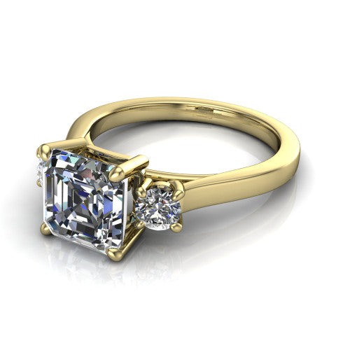 Olivia square emerald three stone engagement ring in 14K Yellow Gold, three-quarter perspective showing the step-cut square emerald center diamond flanked by two round side diamonds on a squared flat-top shank