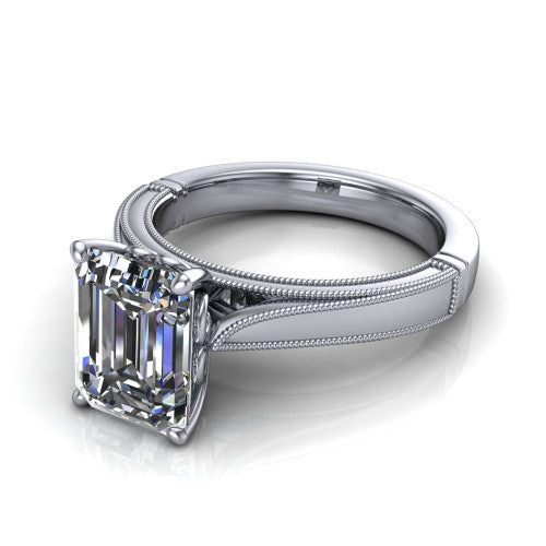 Adeline emerald solitaire engagement ring in Platinum, three-quarter perspective showing the step-cut emerald center diamond on a wide flat-top milgrain band