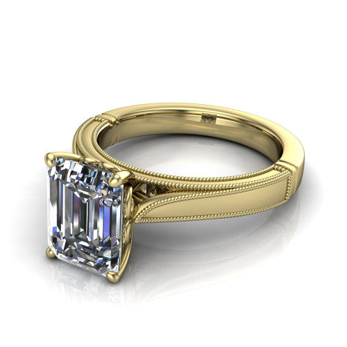 Adeline emerald solitaire engagement ring in 18K Yellow Gold, three-quarter perspective showing the step-cut emerald center diamond on a wide flat-top milgrain band