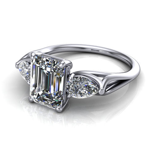Journee emerald three stone engagement ring in 18K White Gold, three-quarter perspective showing the step-cut emerald center diamond flanked by two pear side diamonds set sideways on tapered cathedral shoulders
