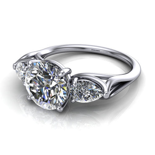 Journee round three stone engagement ring in Platinum, three-quarter perspective showing the brilliant round center diamond flanked by two pear side diamonds set sideways on tapered cathedral shoulders
