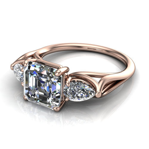 Journee square emerald three stone engagement ring in 14K Rose Gold, three-quarter perspective showing the step-cut square emerald center diamond flanked by two pear side diamonds set sideways on tapered cathedral shoulders