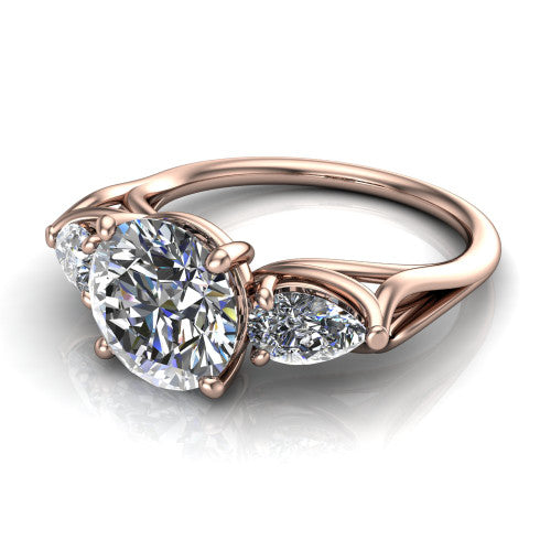 Journee round three stone engagement ring in 18K Rose Gold, three-quarter perspective showing the brilliant round center diamond flanked by two pear side diamonds set sideways on tapered cathedral shoulders