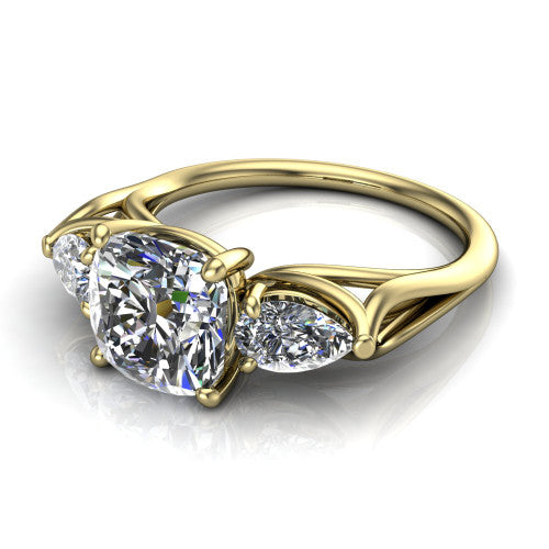 Journee cushion three stone engagement ring in 18K Yellow Gold, three-quarter perspective showing the brilliant cushion-cut center diamond flanked by two pear side diamonds set sideways on tapered cathedral shoulders