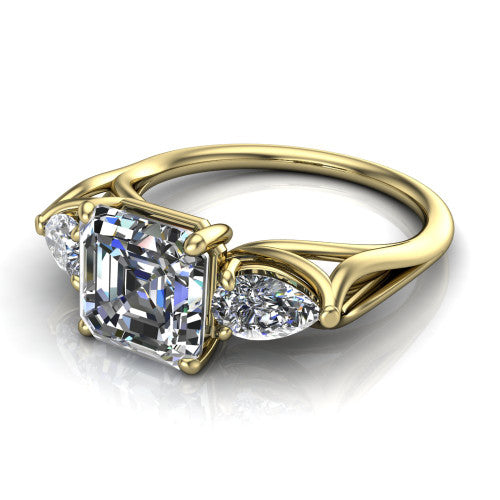 Journee square emerald three stone engagement ring in 18K Yellow Gold, three-quarter perspective showing the step-cut square emerald center diamond flanked by two pear side diamonds set sideways on tapered cathedral shoulders