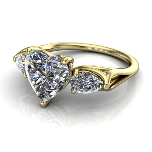 Journee heart three stone engagement ring in 18K Yellow Gold, three-quarter perspective showing the brilliant heart-shaped center diamond flanked by two pear side diamonds set sideways on tapered cathedral shoulders