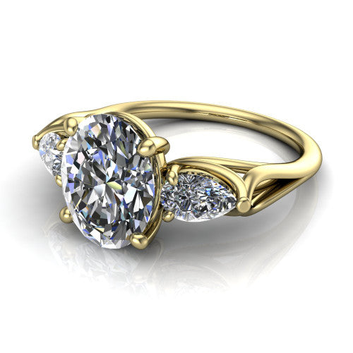 Journee oval three stone engagement ring in 18K Yellow Gold, three-quarter perspective showing the brilliant oval center diamond flanked by two pear side diamonds set sideways on tapered cathedral shoulders
