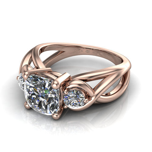 Ottilie cushion three stone engagement ring in 18K Rose Gold, three-quarter perspective showing the brilliant cushion-cut center diamond flanked by two round side diamonds on a braided ribbon shank