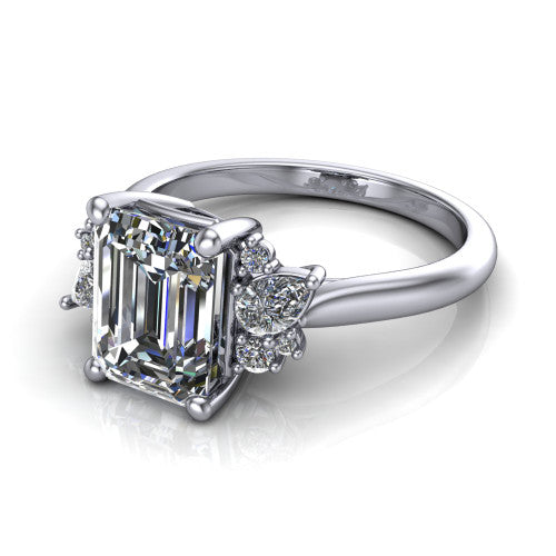 Evie emerald three stone engagement ring in Platinum, three-quarter perspective showing the cathedral rise and accent clusters fanning out on both sides of the center