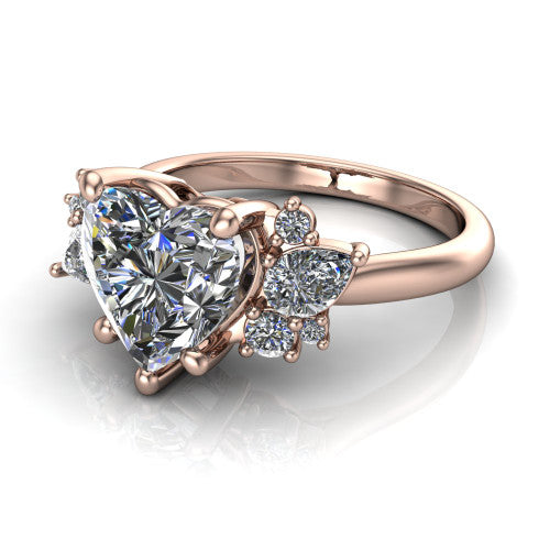 Evie heart three stone engagement ring in 14K Rose Gold, three-quarter perspective showing the cathedral rise and accent clusters fanning out on both sides of the center