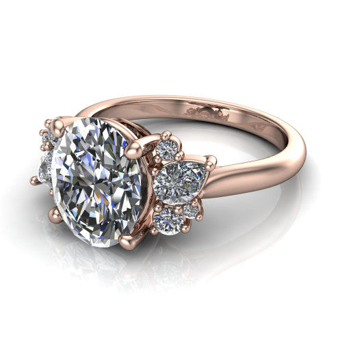 Evie oval three stone engagement ring in 18K Rose Gold, three-quarter perspective showing the cathedral rise and accent clusters fanning out on both sides of the center
