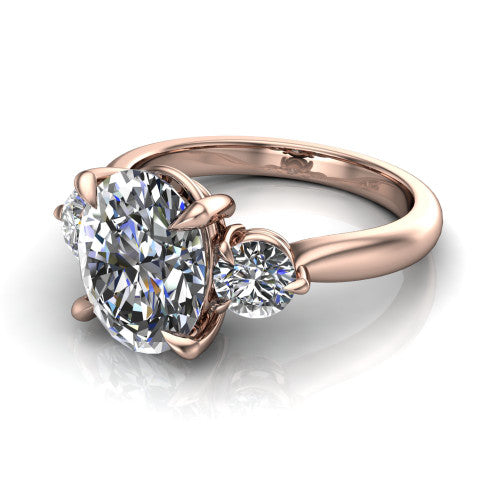 Juniper oval three stone engagement ring in 14K Rose Gold, three-quarter perspective showing the brilliant oval center diamond flanked by two round side diamonds on a rounded plain band