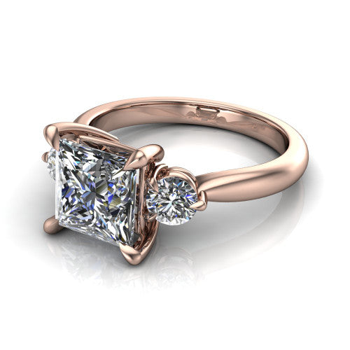 Juniper princess three stone engagement ring in 18K Rose Gold, three-quarter perspective showing the brilliant princess-cut center diamond flanked by two round side diamonds on a rounded plain band