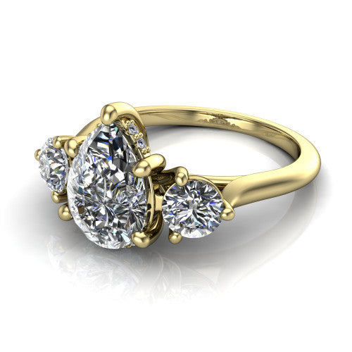 Edith pear hidden halo engagement ring in 18K Yellow Gold, three-quarter perspective showing the brilliant pear-cut center diamond flanked by two round side diamonds with a hidden pave halo beneath the center stone
