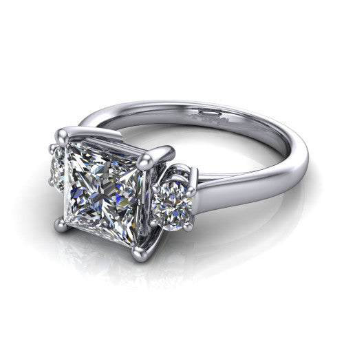 Imogen princess three stone engagement ring in 18K White Gold, three-quarter perspective showing the center diamond between two round side stones on a slim polished band