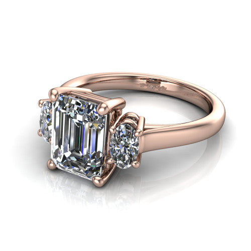 Imogen emerald three stone engagement ring in 18K Rose Gold, three-quarter perspective showing the center diamond between two round side stones on a slim polished band