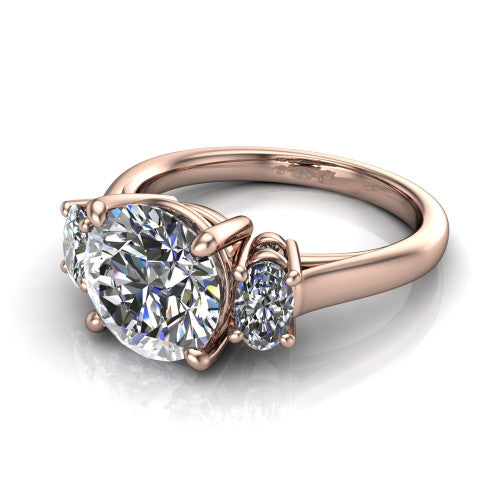 Imogen round three stone engagement ring in 18K Rose Gold, three-quarter perspective showing the center diamond between two round side stones on a slim polished band