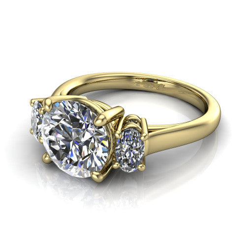 Imogen round three stone engagement ring in 18K Yellow Gold, three-quarter perspective showing the center diamond between two round side stones on a slim polished band