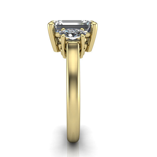 Imogen emerald three stone engagement ring in 18K Yellow Gold, side profile showing the round side stone and the smooth tapered polished band